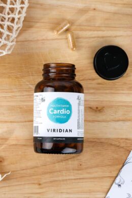 cardio multivitamin jar on a wooden table next to garlic cloves and a couple of capsules