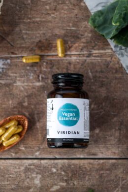 essential vegan multivitamin jar 30 caps kept with a spoonful of capsules