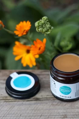 viridian calendula hypericum organic balm jar opened kept in natural lighting next to flowers